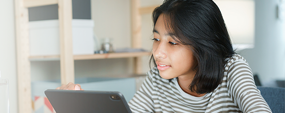 security-570x227 Young girl smiling at what she is watching on her iPad.